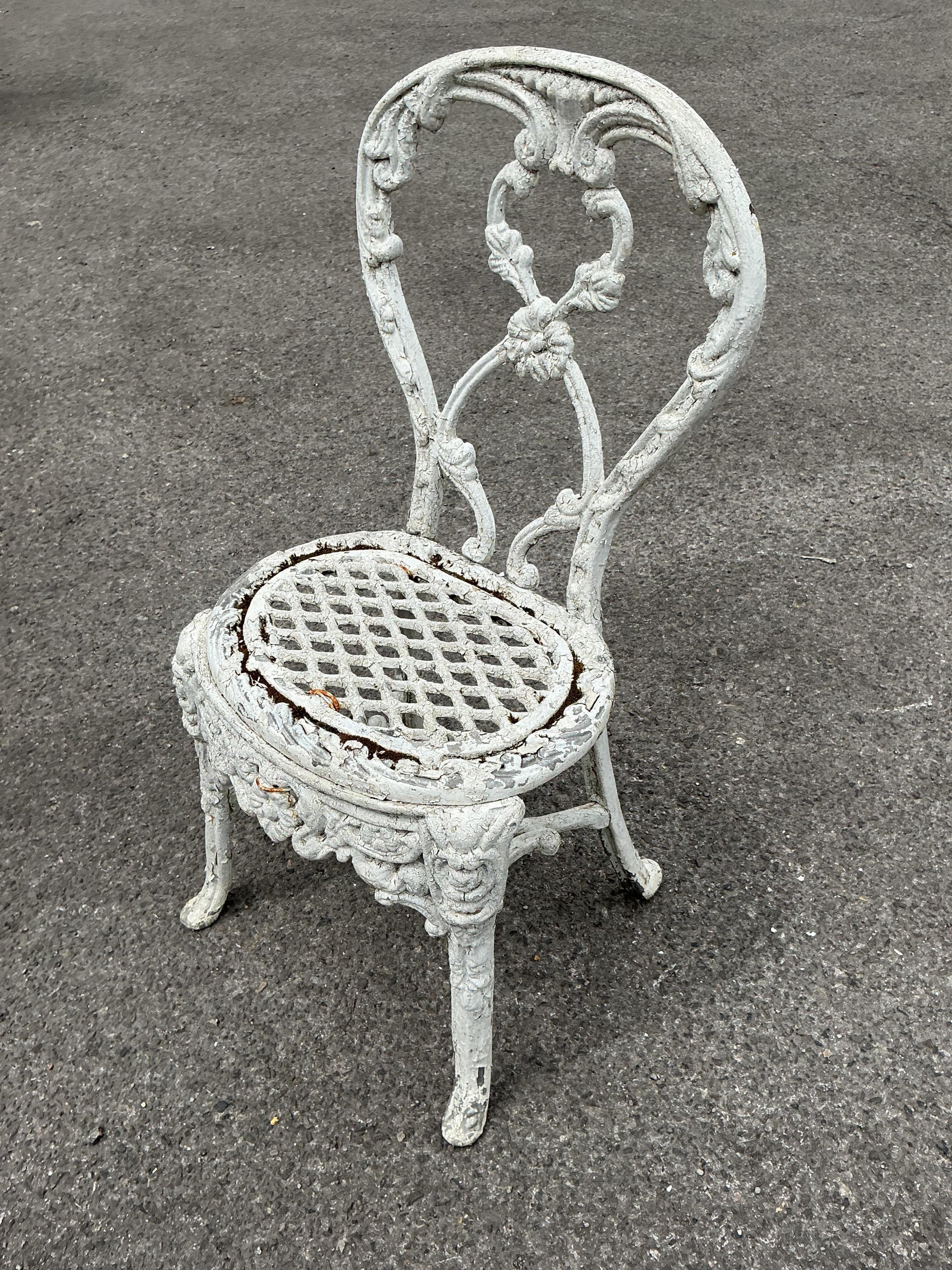 A Victorian Coalbrookdale style later painted circular cast iron garden table, diameter 61cm, height 70cm together with two later chairs